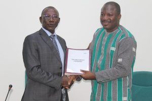 Le Directeur de Cabinet, Alassane GUIRE remettant les cahiers de charges au nouveau Secrétaire technique