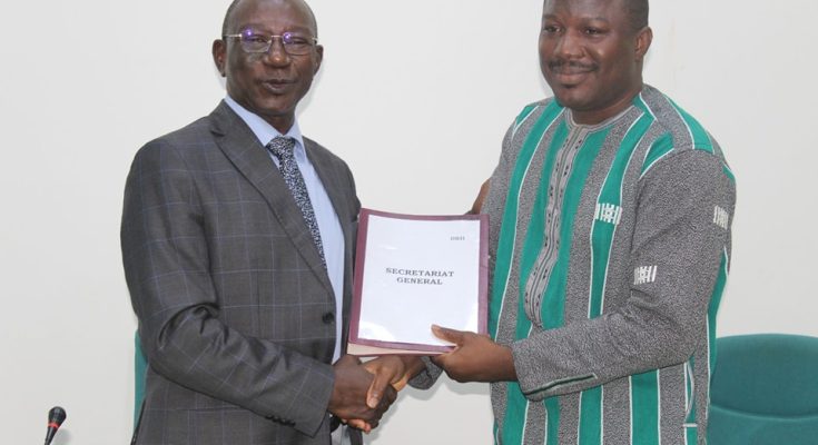Le Directeur de Cabinet, Alassane GUIRE remettant les cahiers de charges au nouveau Secrรฉtaire technique